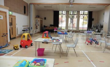 A photo of a hall with childrens toys and desks