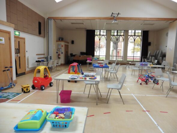 A photo of a hall with childrens toys and desks