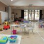 A photo of a hall with childrens toys and desks