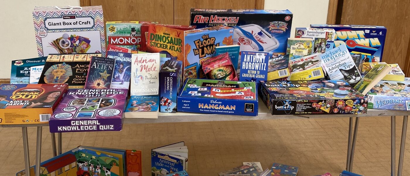 Image of a table piled with boxed board games and toys