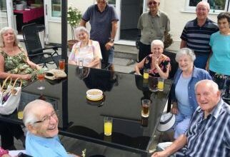 Photograph of a group of people sitting around a garden table