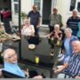 Photograph of a group of people sitting around a garden table