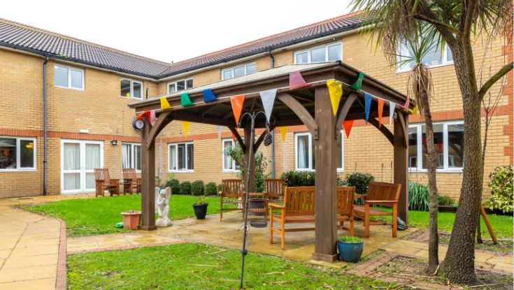 The photo shows the seating area in the garden and the gazebo