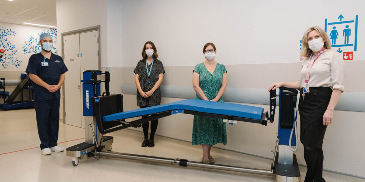 An image of 4 people standing by a piece of hospital equipment