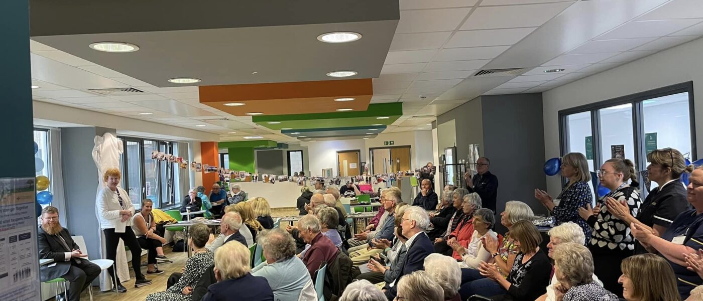A photo of a large group of people at a meeting