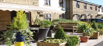 Photograph showing small trees and shrubs at the entrance to the care home
