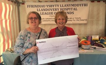 A photo of two ladies holding a large donation cheque