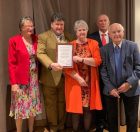 A photo of Attend Chief Executive David Wood, presenting long service certificates to volunteers